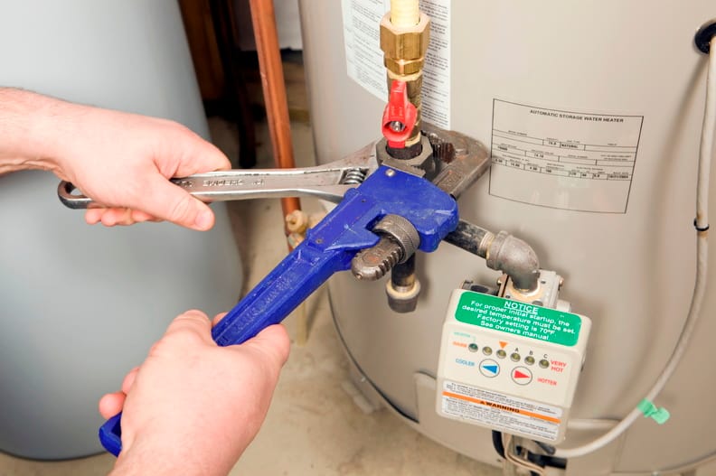 Plumber repairing water heater pipe connection in Venice, Florida home