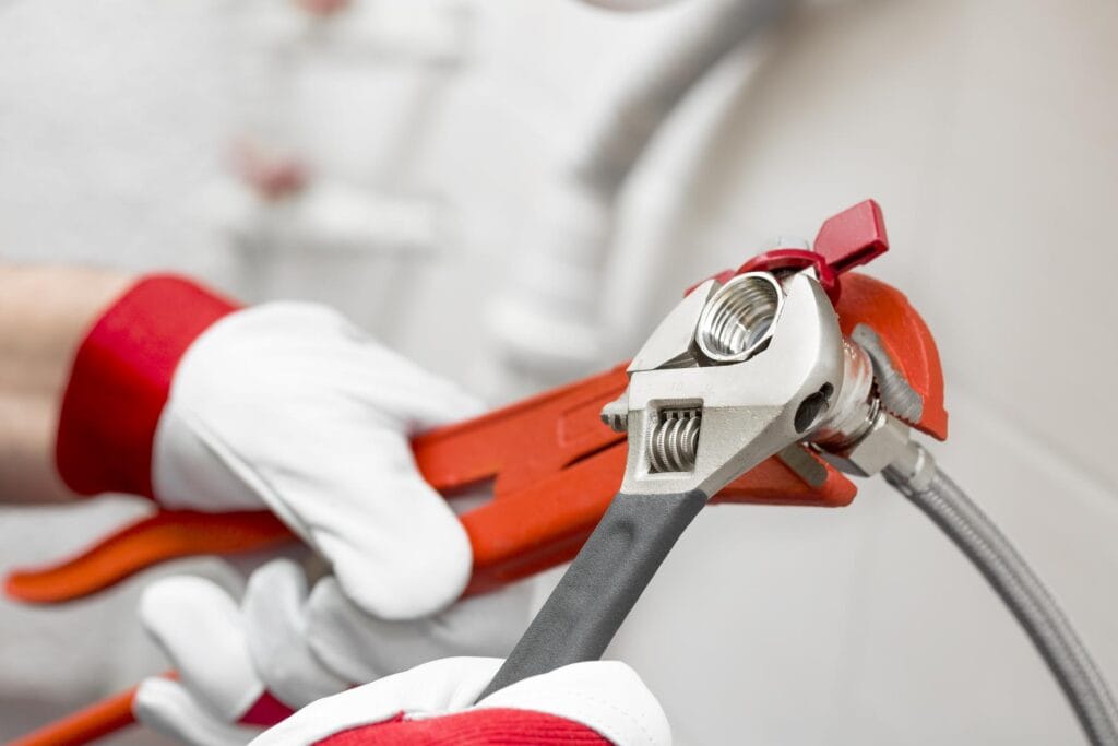 Plumber tightening pipe fitting for residential plumbing repair in Venice, Florida
