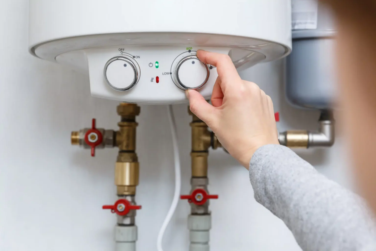 Homeowner adjusting the temperature controls on a water heater in Venice